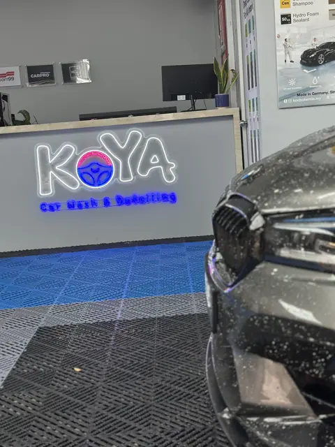 Snow foam on BMW headlamp in front of KOYA counter