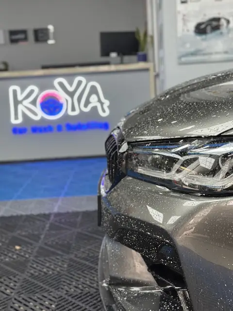 Snow foam on BMW headlamp in front of KOYA counter